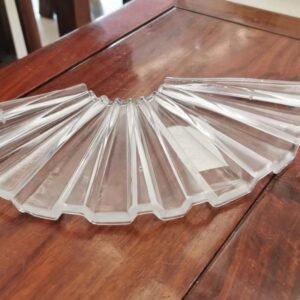 A clear glass chandelier part shaped like a fan with multiple elongated and radiating facets. It showcases intricate, sharp-edged lines and a polished surface, reflecting light beautifully. The base is slightly thicker, emphasizing its handcrafted nature and stability. This decorative component is ideal for enhancing the elegance of a chandelier.